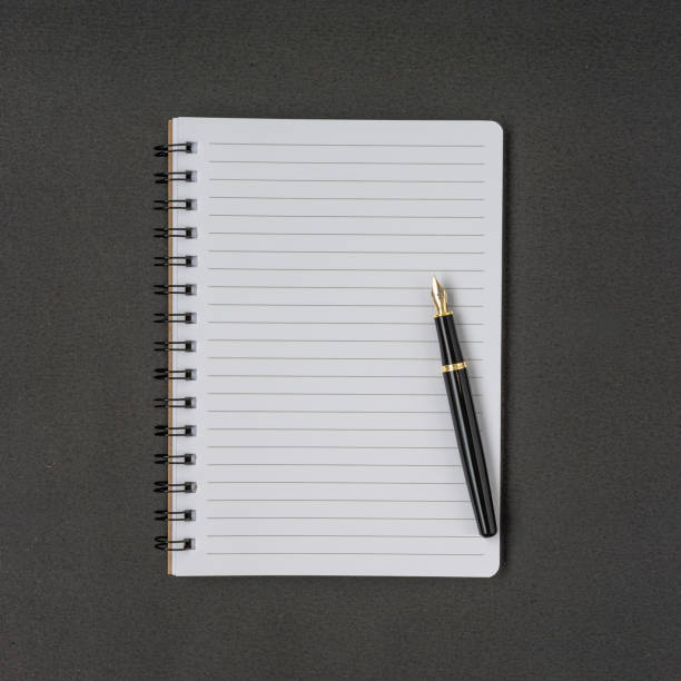 istock A pen and notebook with a copy space on black background. Flat lay. 1308987654