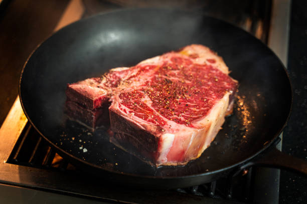 istock T-bone steak frying on cast iron pan 1308992944