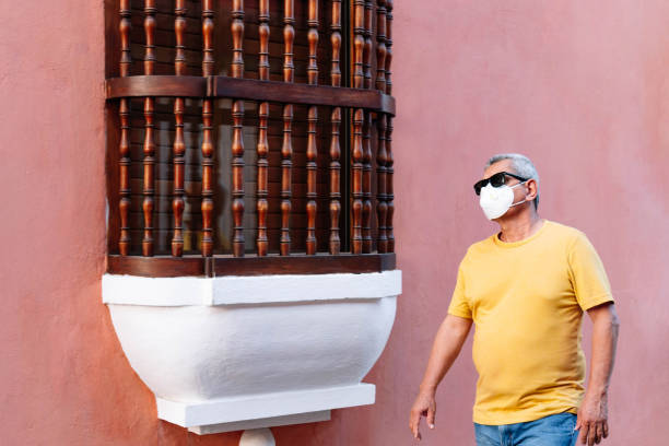 istock Older man wearing protective mask walking down the street 1308994676