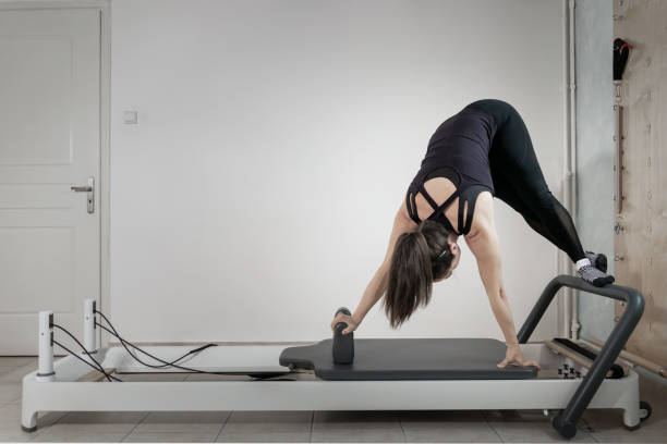 istock A woman doing pilates exercises on a reformed bed. 1308995332