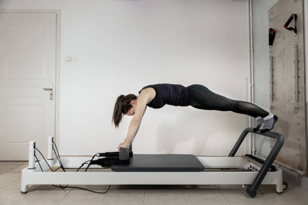 istock A woman doing pilates exercises on a reformed bed. 1308995427