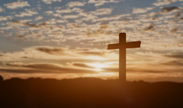 istock Silhouette of catholic cross at sunset background. 1309007229