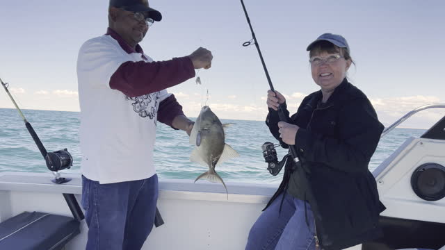 Boat Captain Holds Up A Trigger Fish A Smiling Middle-Aged Woman Just Caught Off The Reef In The Sea Of Cortez, Mexico, Puerto Penasco, Video