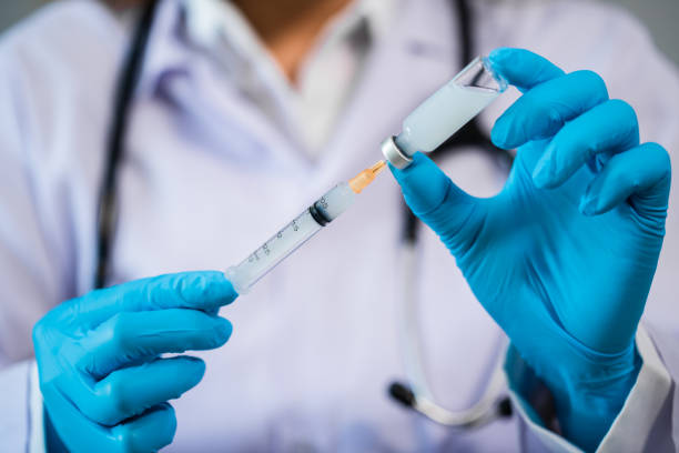 istock doctor drawing vaccine bottle into syringe injection 1309016780