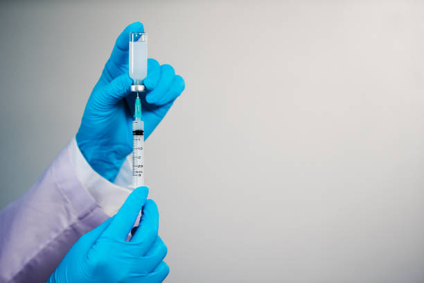 istock hand drawing vaccine bottle into syringe injection medicine 1309016781