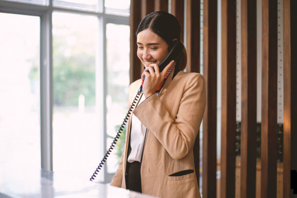 The hotel receptionist was answering a phone call to provide information to customers. The hotel receptionist was answering a phone call to provide information to customers. concierge photos stock pictures, royalty-free photos & images