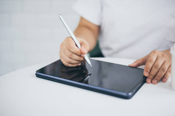 istock Female hands holding and using digital pen writing on taplet screen , freelance working business at home 1309018552