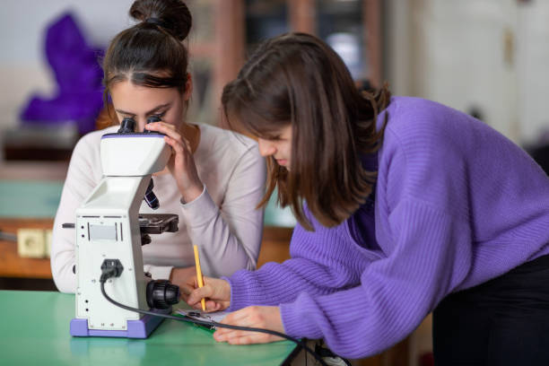 istock High school girls performing project for biology class in microscopy lab 1309019571