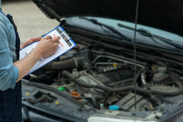 istock Man writing car checklist while working in auto repair shop. 1309029012