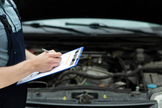 istock Man writing car checklist while working in auto repair shop. 1309029080