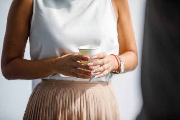 istock Elegant woman's manicured hands holding disposable coffee cup 1309033071