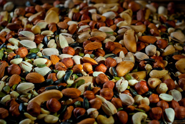 istock Many types of nuts close up. Textures of different nuts. Nuts are dumped in a pile. Contrasting dramatic light as an artistic effect. 1309033307