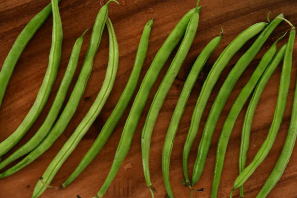 istock Fresh green beans on wooden background. 1309034411