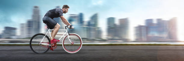 istock Fast riding cyclist in front of a city skyline 1309034518