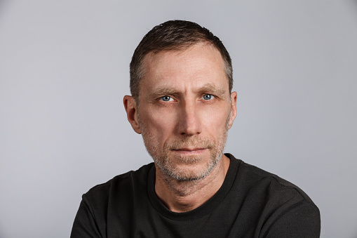 Beard man wearing t-shirt on light gray background. Studio shot.