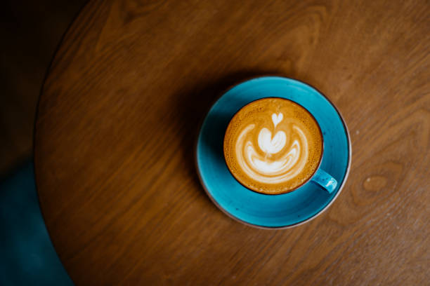 istock Flat white coffee in blue cup on top of wooden table 1309036443