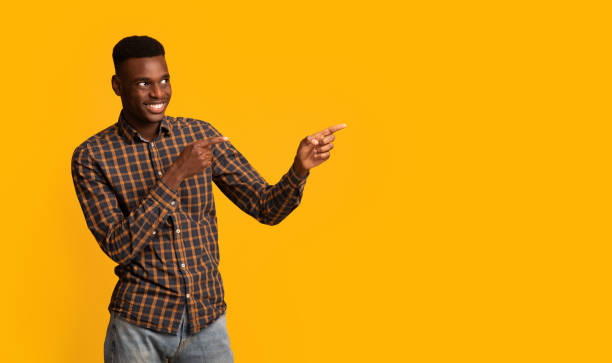 istock Look There. Cheerful African American Guy Pointing Aside At Copy Space 1309037688
