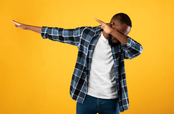 Black Guy Throwing Dab Gesture Posing Standing On Yellow Background Black Guy Throwing Dab Gesture Having Fun Posing Standing On Yellow Studio Background. African American Millennial Man Making Internet Meme Dabbing Pose dab dance stock pictures, royalty-free photos & images