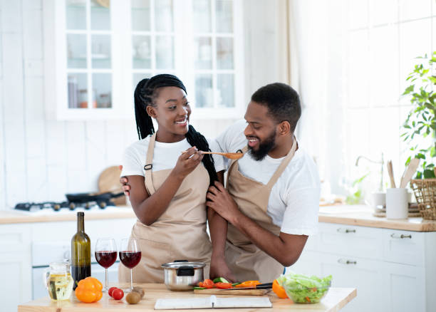 istock Joyful Black Spouses Tasting Food While Cooking Lunch In Kitchen 1309038240