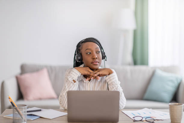 自宅でオンライントレーニングを持っているペンシブブラックレディ - braids african descent women pensive ストックフォトと画像