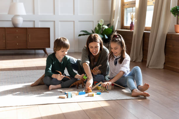 istock Happy mom and small kids relax at home playing 1309039173