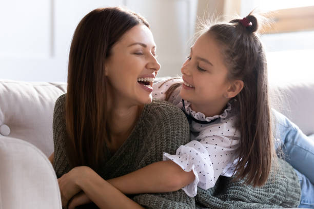 istock Happy mom and small daughter lying on couch 1309039206