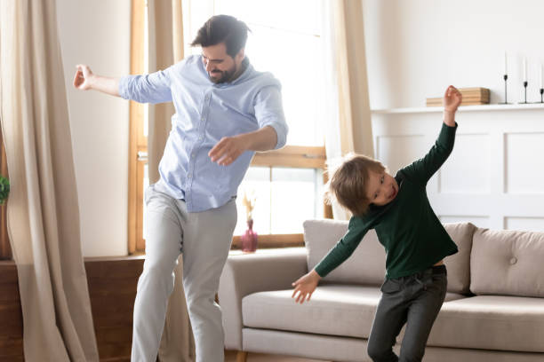 istock Excited young dad with little son dancing at home 1309039222
