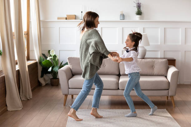 istock Happy mom and small daughter dancing on weekend at home 1309039224