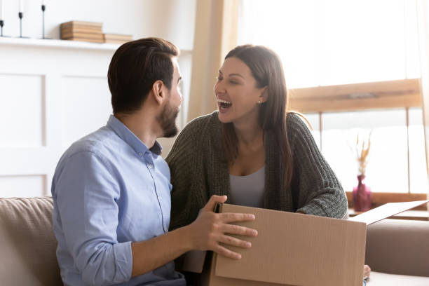 istock Excited couple have fun unboxing parcel with internet order 1309039237