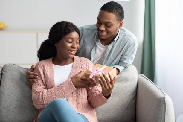 istock Romantic black guy giving present to his happy girlfriend 1309039405