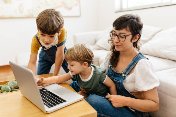 istock Kids using laptop with mother at home 1309040631