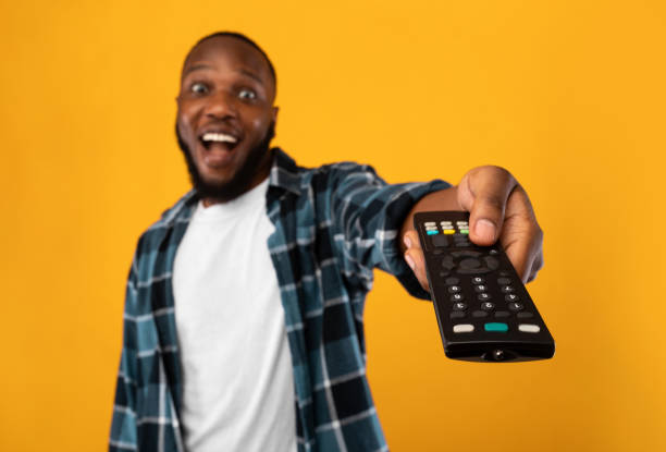 istock Excited African Man Pointing Television Controller To Camera, Yellow Background 1309041786