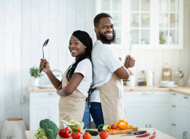 istock Cheerful Black Spouses Wearing Aprons Posing In Kitchen While Cooking Dinner Together 1309042022