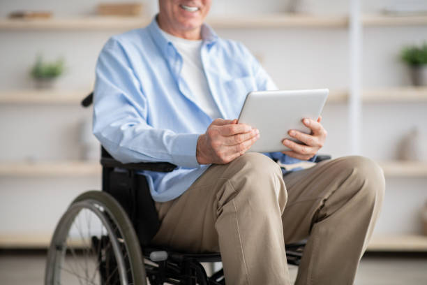 istock Cropped view of disabled senior man in wheelchair using tablet computer for online communication at home 1309042479