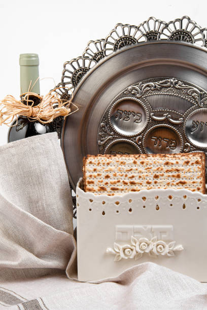 matzo w specjalnym pudełku (z napisem "matzo"), butelkę wina i metalową tacę na jasnym tle. tło wielkanocne. wielkanoc (pascha) seder koncepcja obchodów wielkanoc. - seder haggadah judaism israel zdjęcia i obrazy z banku zdjęć