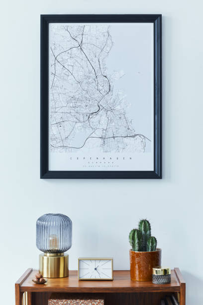 istock Stylish scandinavian living room interior with retro commode, black mock up poster frame, clock, cacti decoration, book, table lamp and personal accessoreis in home decor. Template 1309043490