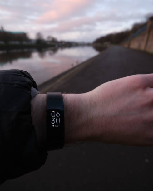 Fitbit showing the time. Nottingham, England - March,15,2021: Photo of a Fitbit being used to tell the time during a morning walk along Nottinghams' embankment. Fitbits and other fitness technology have become popular during the UKs' national lockdown as more people look to stay fit whilst gyms are closed. nottinghamshire stock pictures, royalty-free photos & images