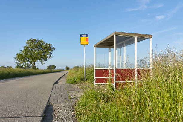 Bus stop shelter in a rural area Bus stop shelter with glass on a road in a rural area under a blue sky. bus shelter stock pictures, royalty-free photos & images