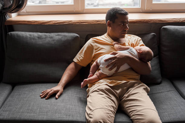 istock Man holding his newborn baby and looking away while spending time together 1309045029