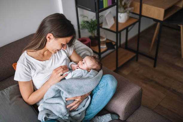 istock Young mother hugging her newborn baby while relaxing at her home. 1309046843