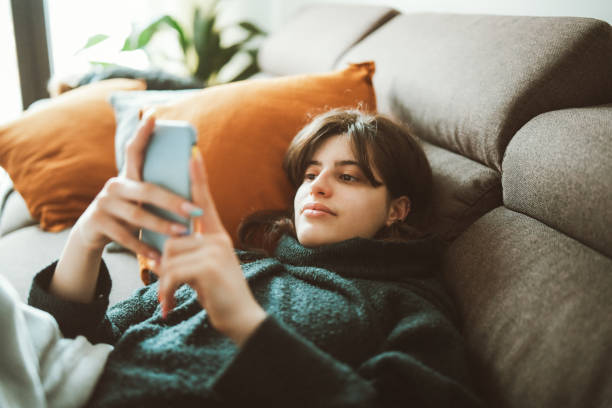 istock Young woman relaxing at home and using a technology 1309046864