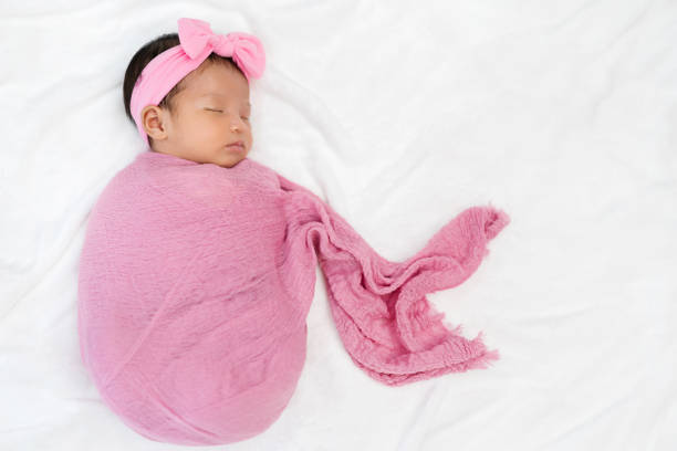 istock newborn baby sleep in cloth wrap blanket on a bed 1309047519