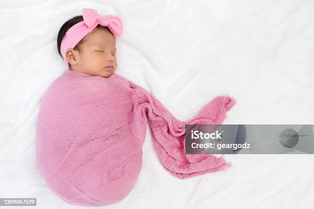 Newborn Baby Sleep In Cloth Wrap Blanket On A Bed Stock Photo - Download Image Now - Baby Blanket, Asia, Asian and Indian Ethnicities