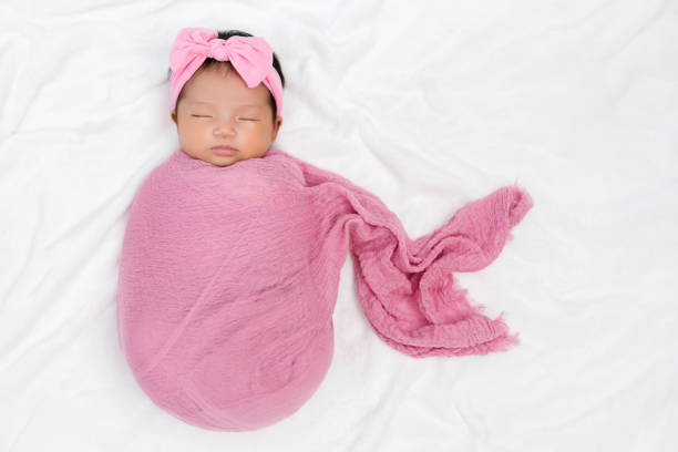 istock newborn baby sleep in cloth wrap blanket on a bed 1309047521