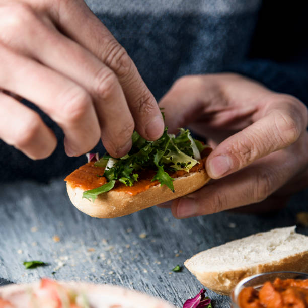 istock young man tops a vegan appetizer with lettuce 1309047767