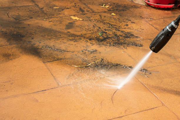 istock Selective focus. Cleaning backyard paving tiles with high pressure washer. 1309049371