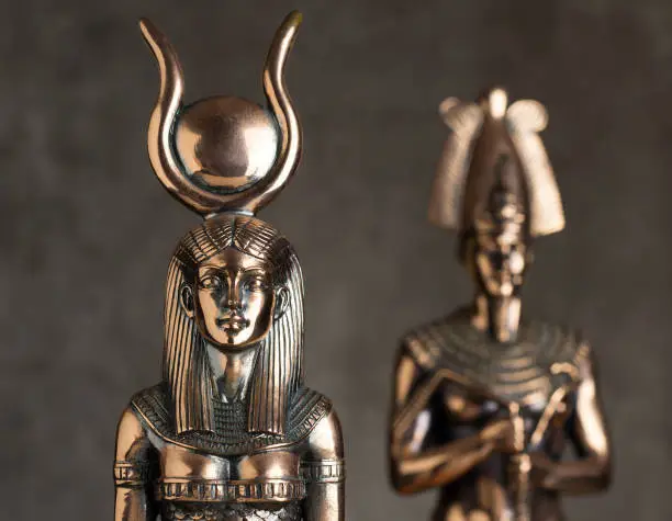 Egyptian goddess Isis with Tutankhamun on a brown background.