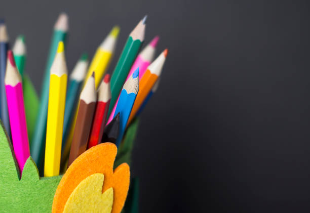 istock Colored pencils in a textile stand on a black background. DIY pencil holder. 1309052858