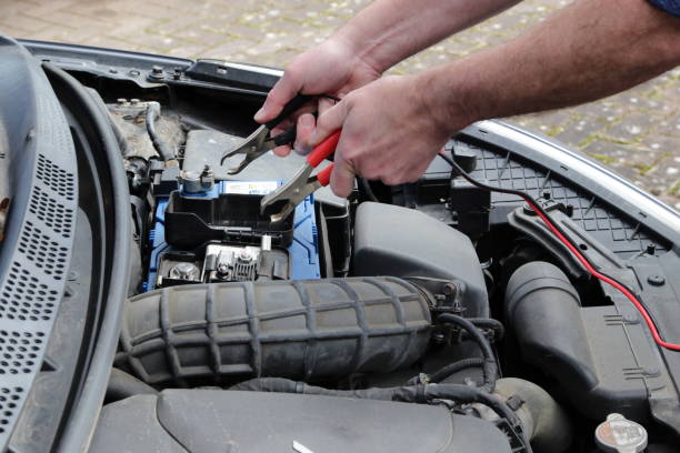 Charging up a car battery Hands with cables charging up a car battery in engine bay animals charging stock pictures, royalty-free photos & images