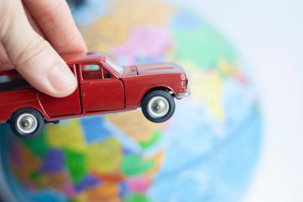 istock Toy car in hand circling the globe 1309055764